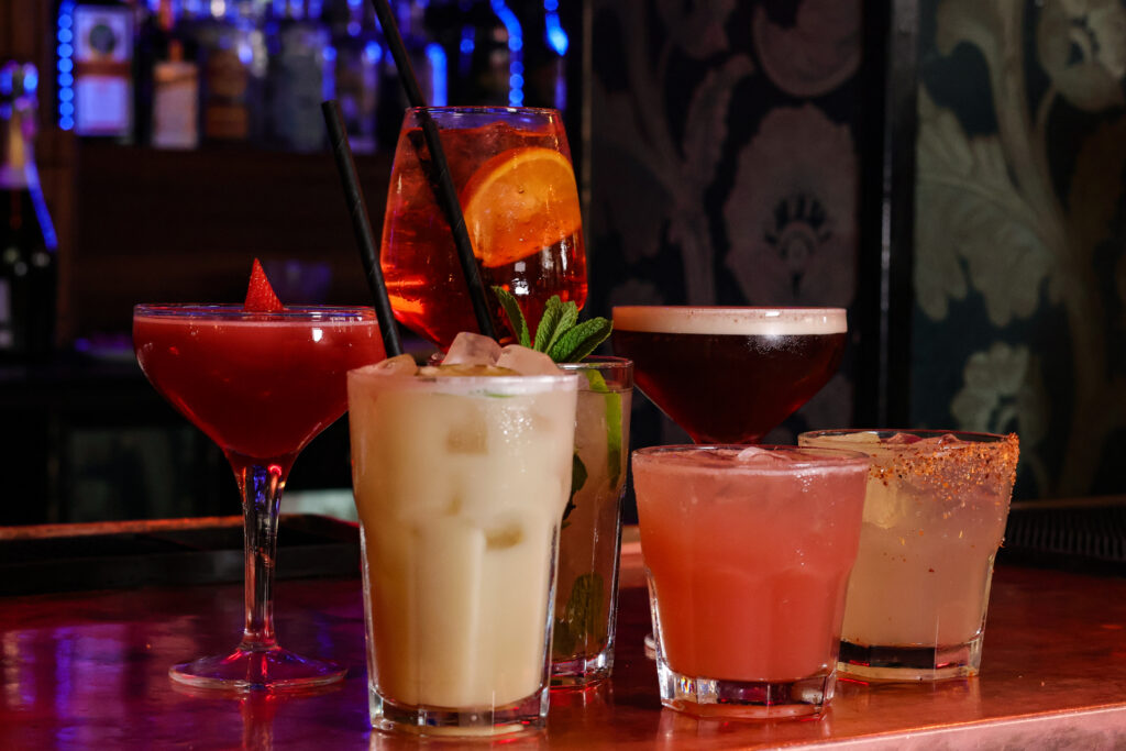 Stylish cocktail bar in Cardiff with vibrant lighting, private booths, and expertly crafted cocktails